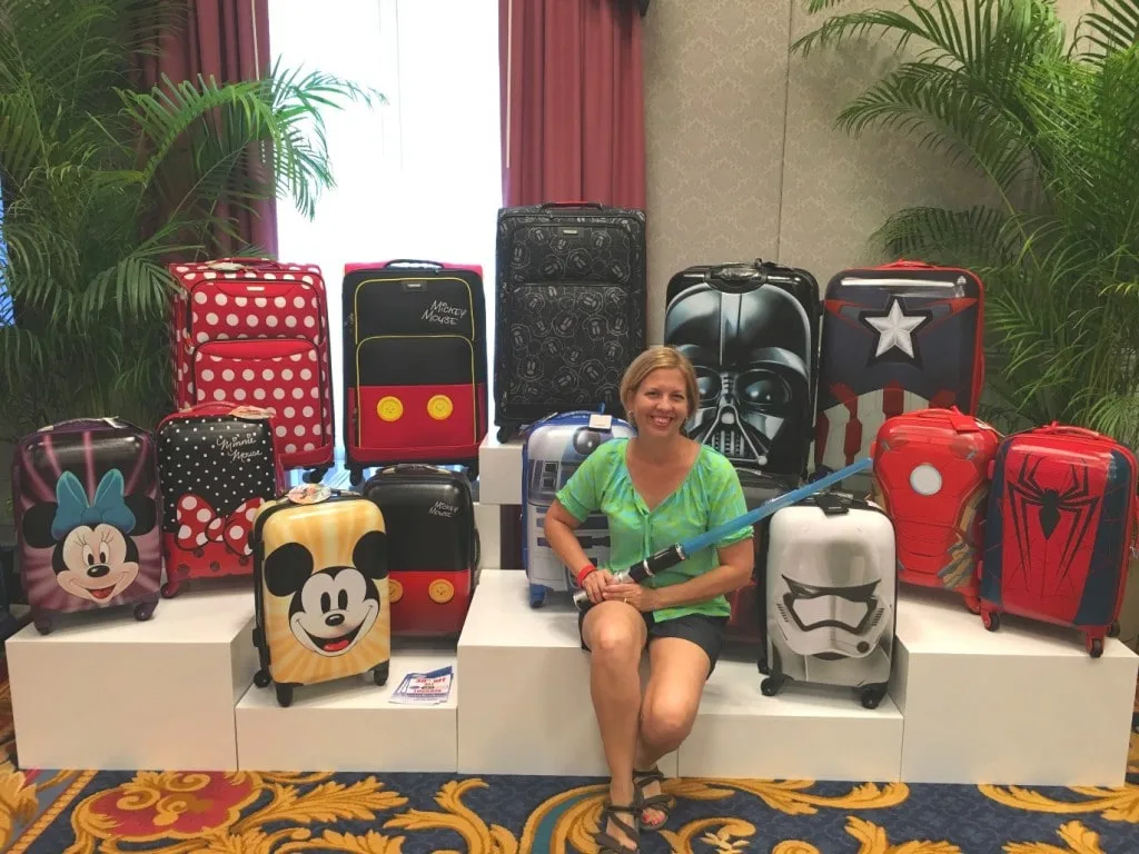 woman sitting among disney suitcases and carry on luggage