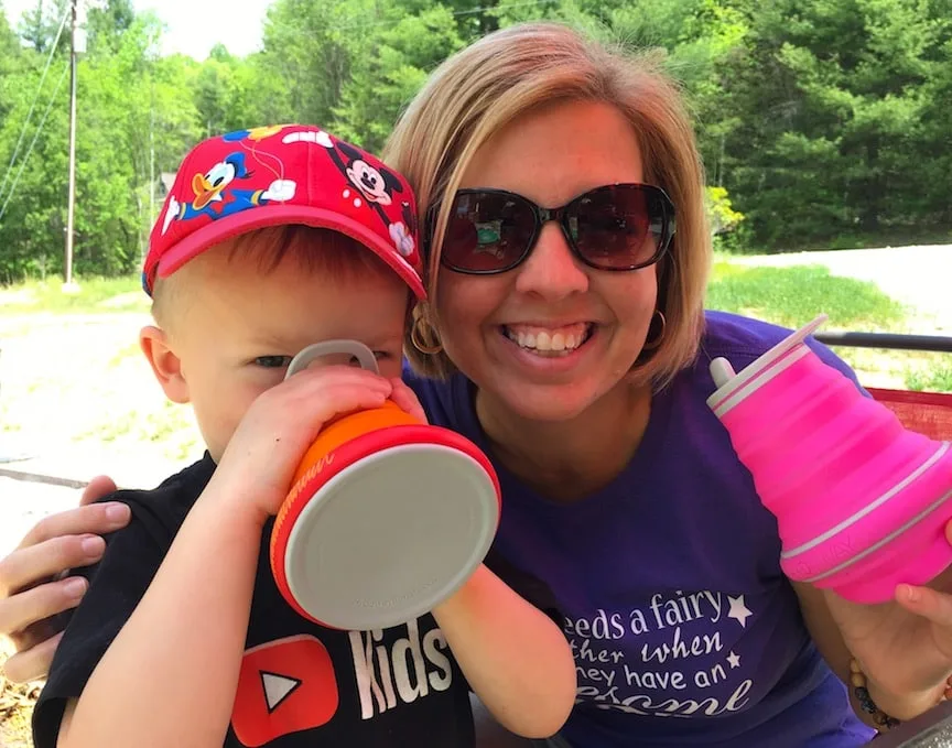 Woman with pink collapsible water bottle and boy with orange collapsible water bottle for Disney World