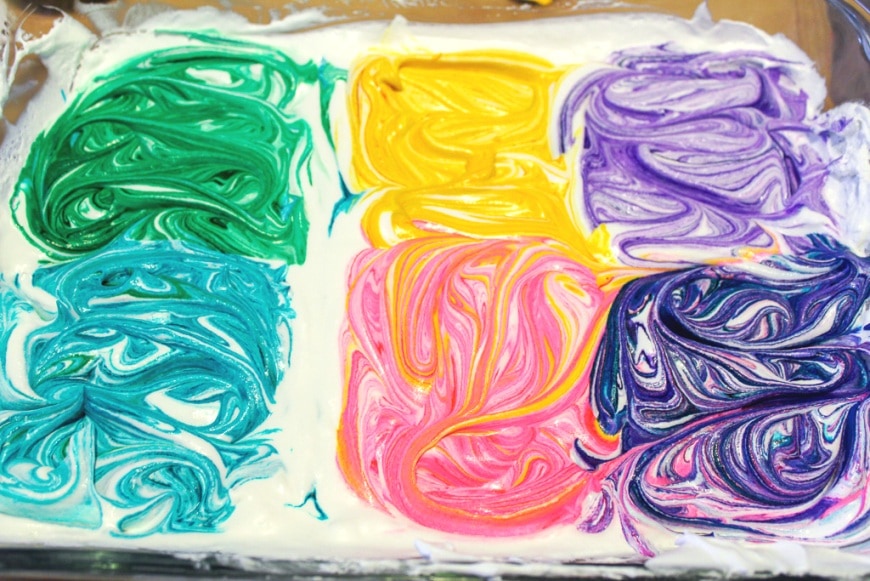 white whipped cream with colorful swirls of food coloring rainbow