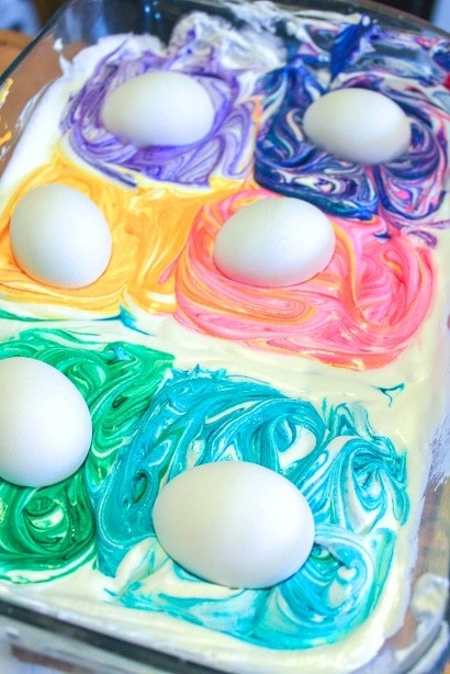white eggs laying in colored whipped cream