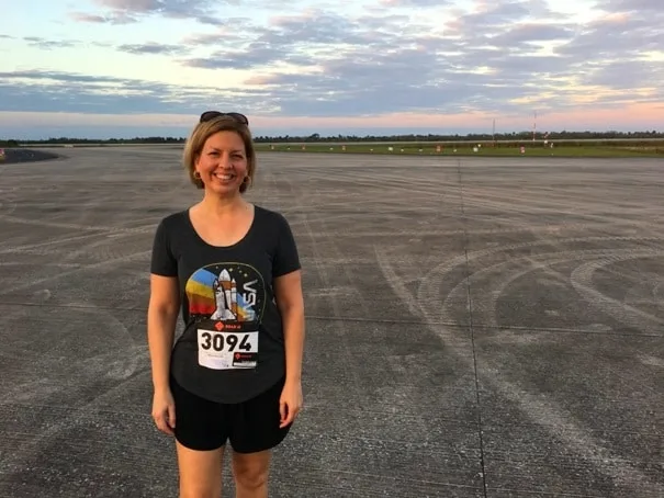 Woman standing on runway wearing race number 