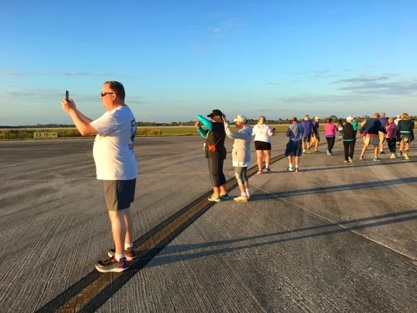 race runners stopping on a runway to take pictures in the morning light