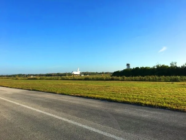 runway with grass and space shuttle and tower in the distance