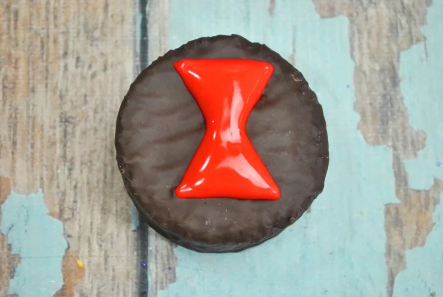 black widow logo on chocolate cake in red icing