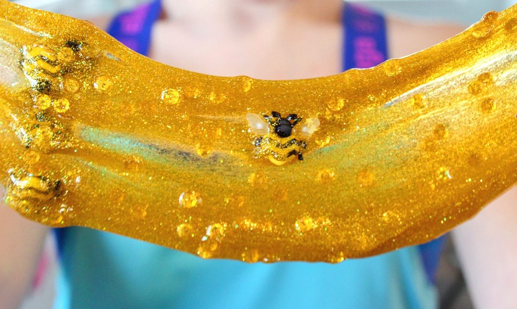 pulled honey colored slime with gold sequins and bumble bees