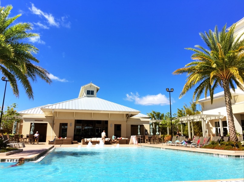 aqua colored water in a pool against blue sky with plam trees