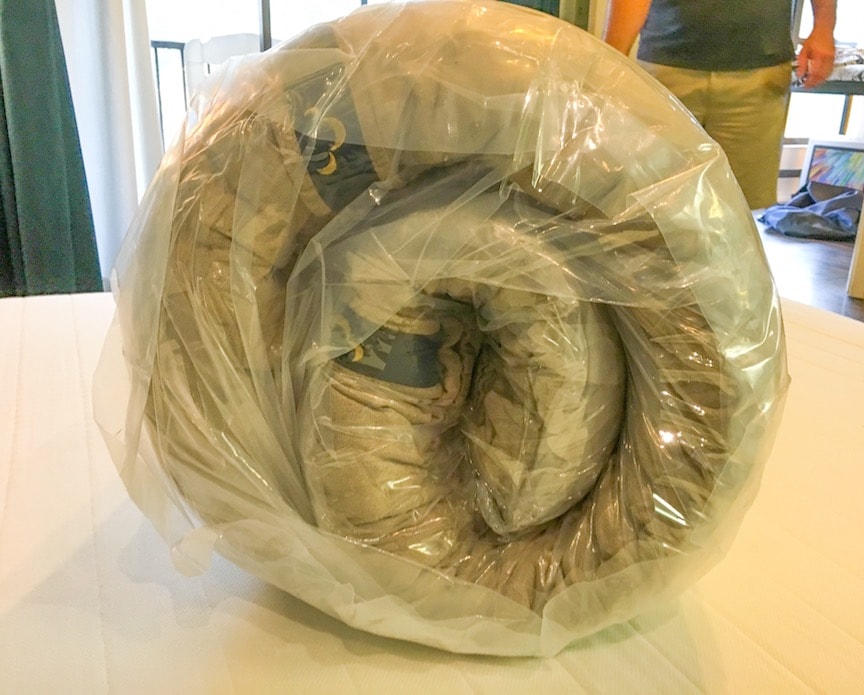 Dreamcloud mattress rolled up in plastic shown from the side