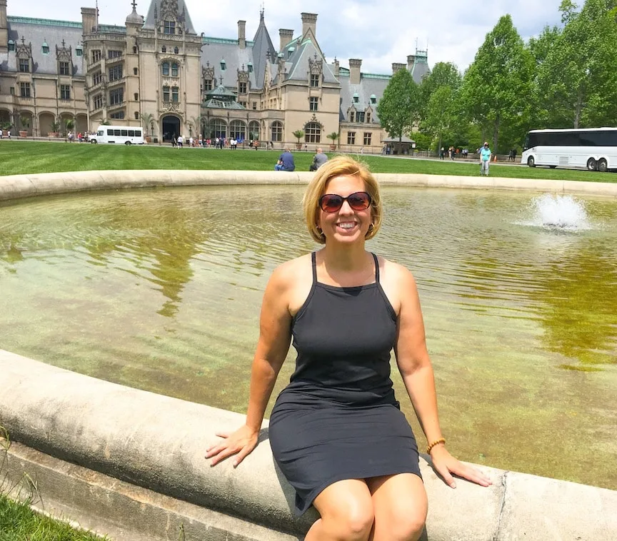sitting on fountain in front of Biltmore Estate house