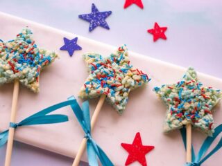 star shaped Rice Krispies treats with blue and red sprinkles on a pink background