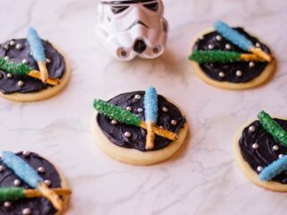 Star Wars light saber cookies with blue and green light sabers on black frosting