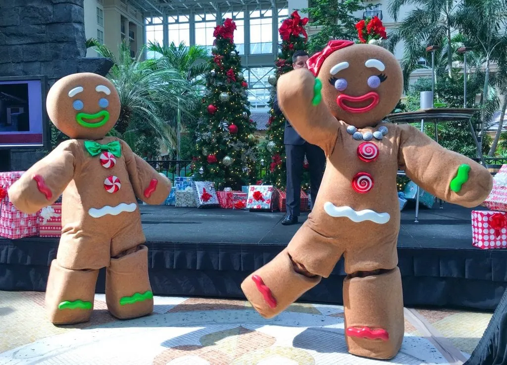 gingerbread men costumes in front of Christmas trees