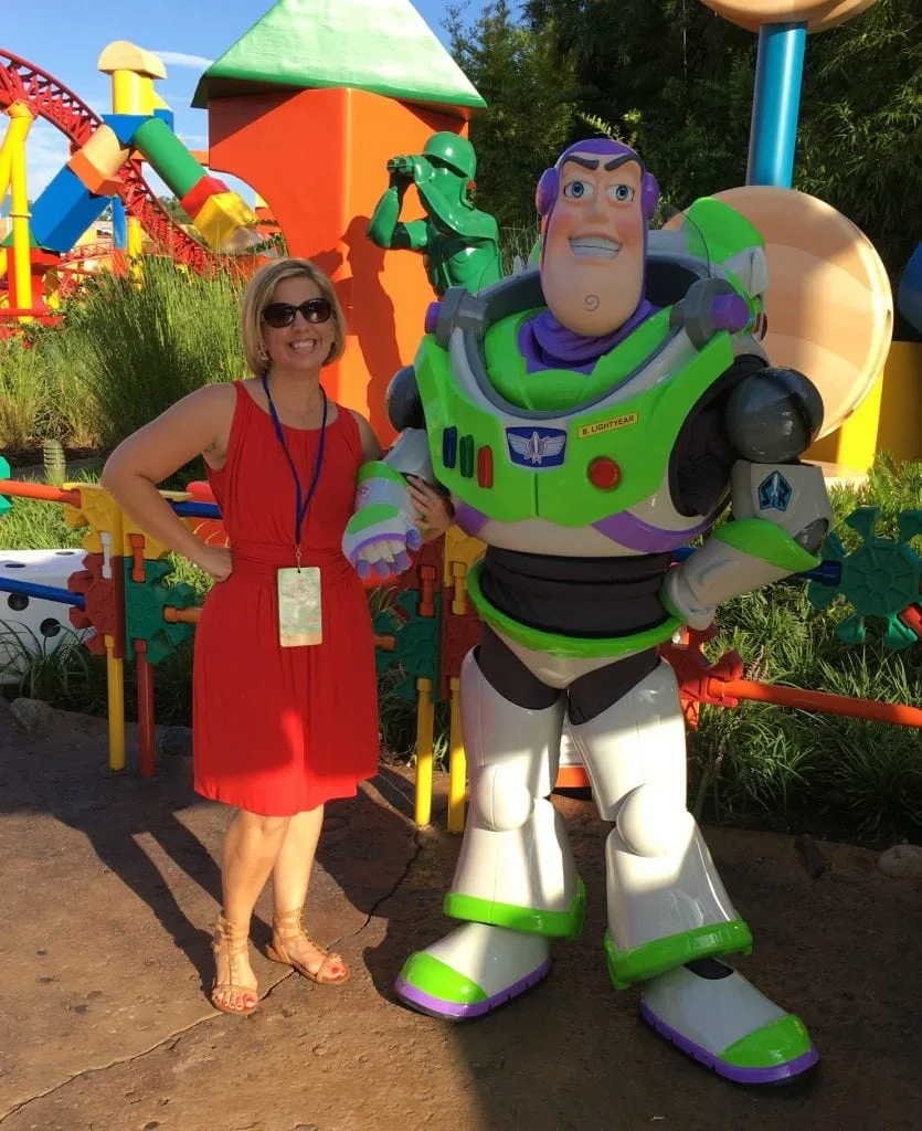 woman in red dress with buzz lightyear toy story land