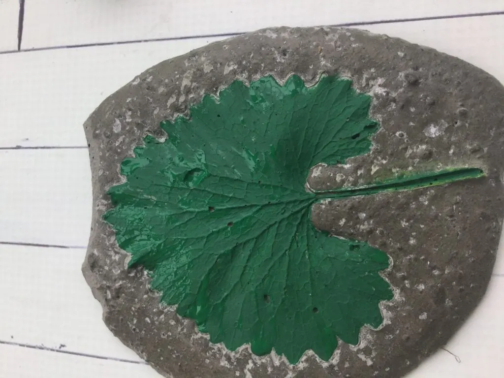 green painted leaf in decorative cement garden stone 