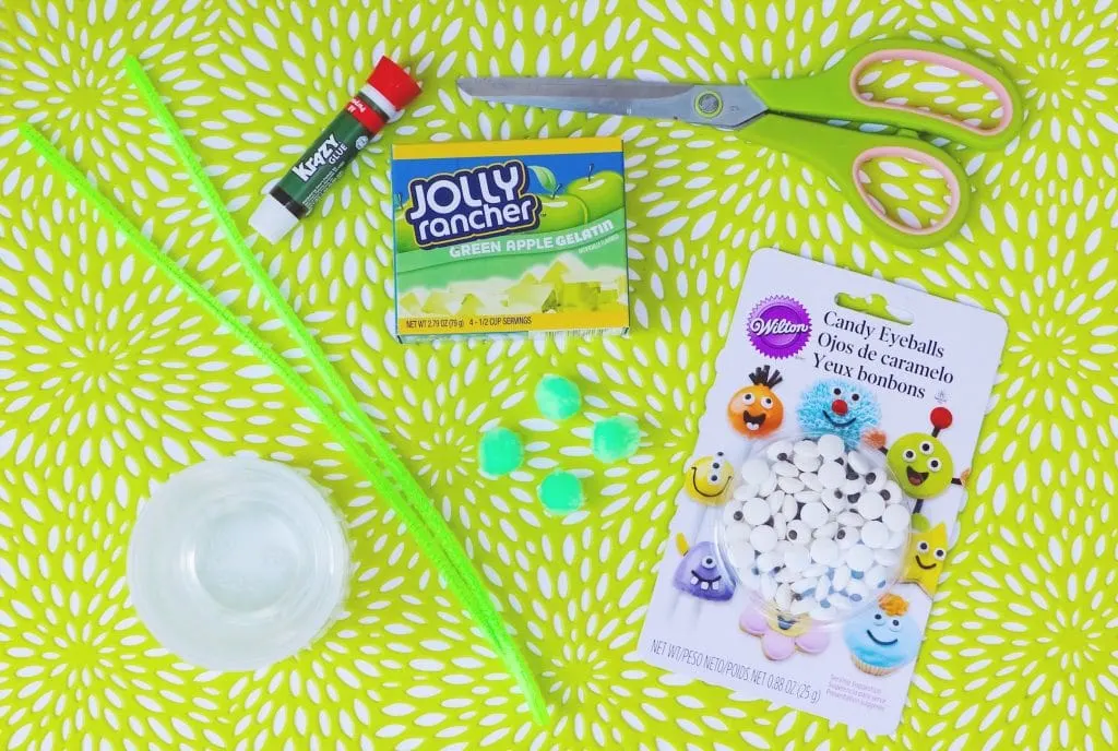 green pipe cleaners gelatin box scissors glue and candy eyes