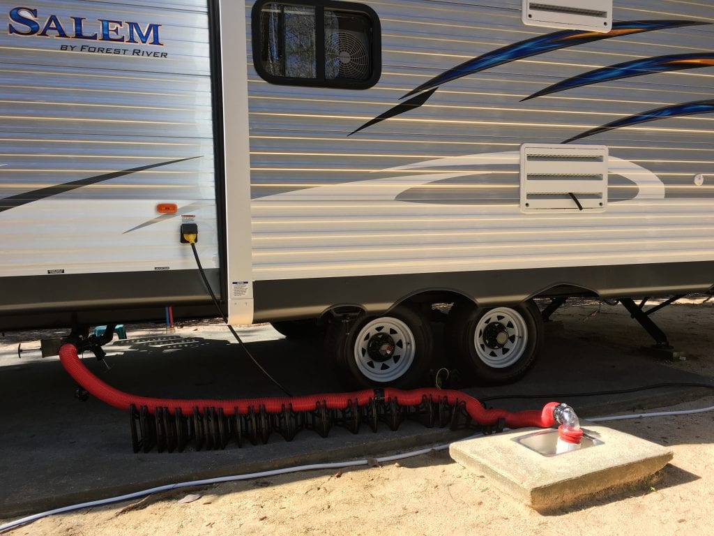 red sewer hose hooked up from RV to dump tank