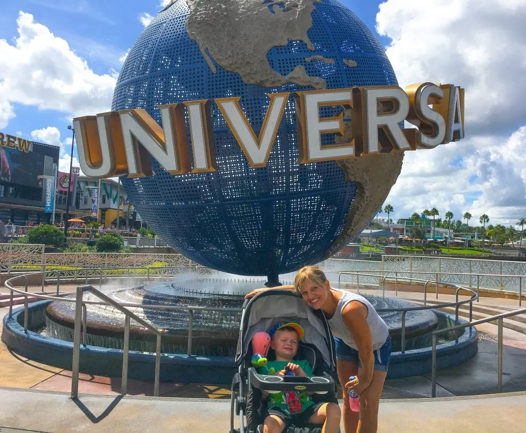 mother and son in front of Universal Studios Orlando sign