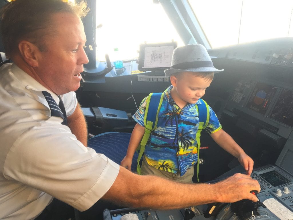 pilot showing young boy airplane cockpit