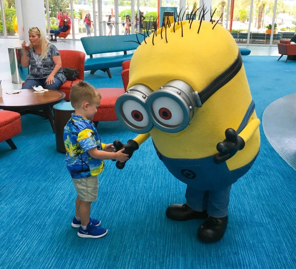 young boy shaking hands with minion character at Universal Studios