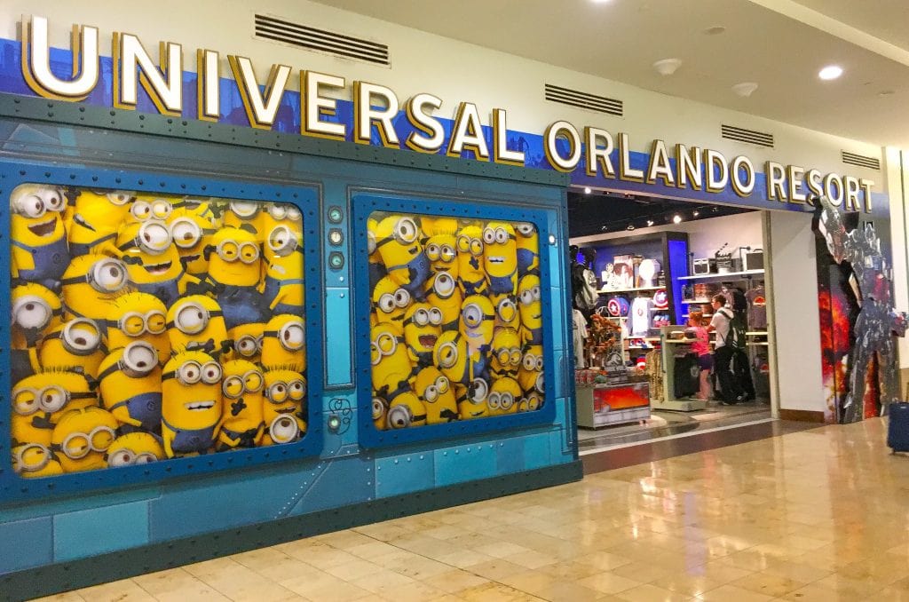 yellow Minions looking out a window at Universal Orlando store at MCO Orlando International Airport