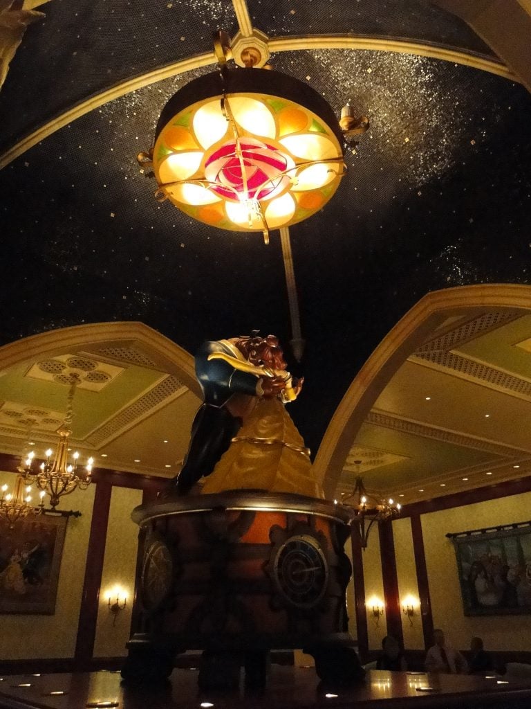 Beauty and the Beast large music box underneath rose light in Be Our Guest Restaurant 