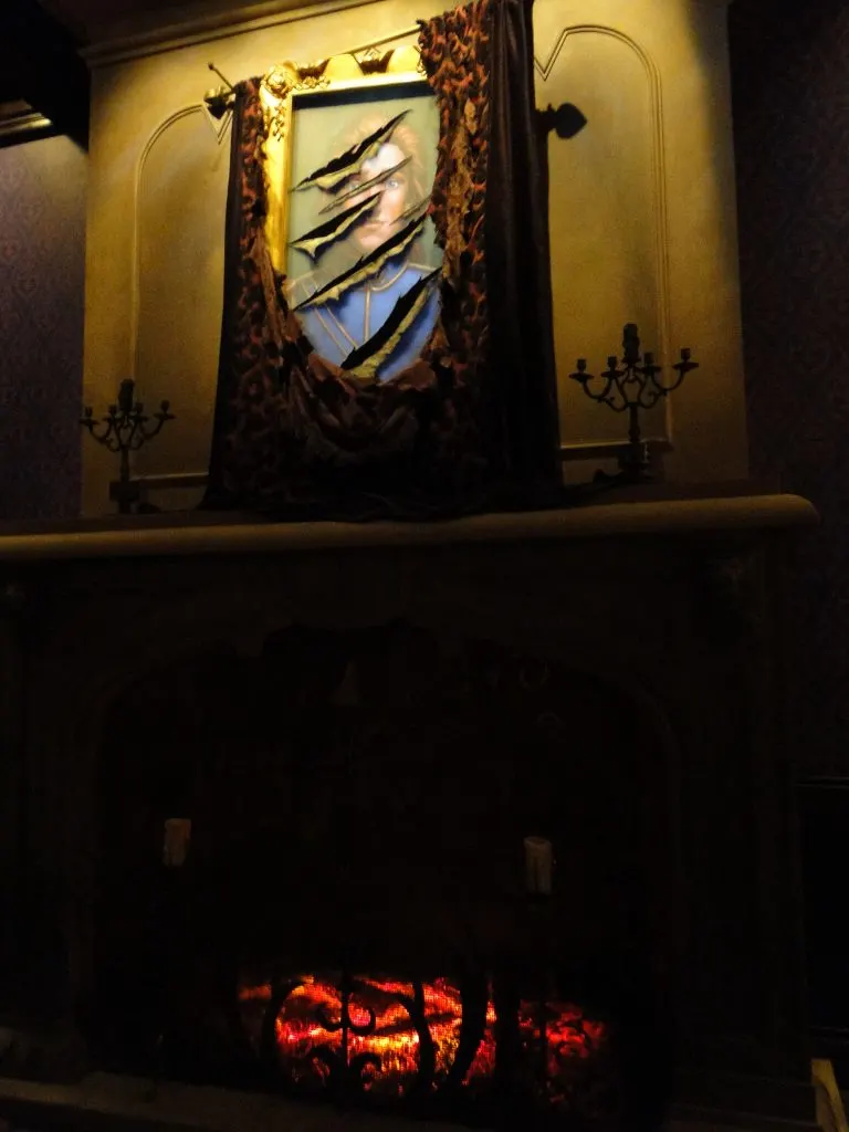 torn painting from Beauty and the Beast on wall above fireplace in Be Our Guest Restaurant 