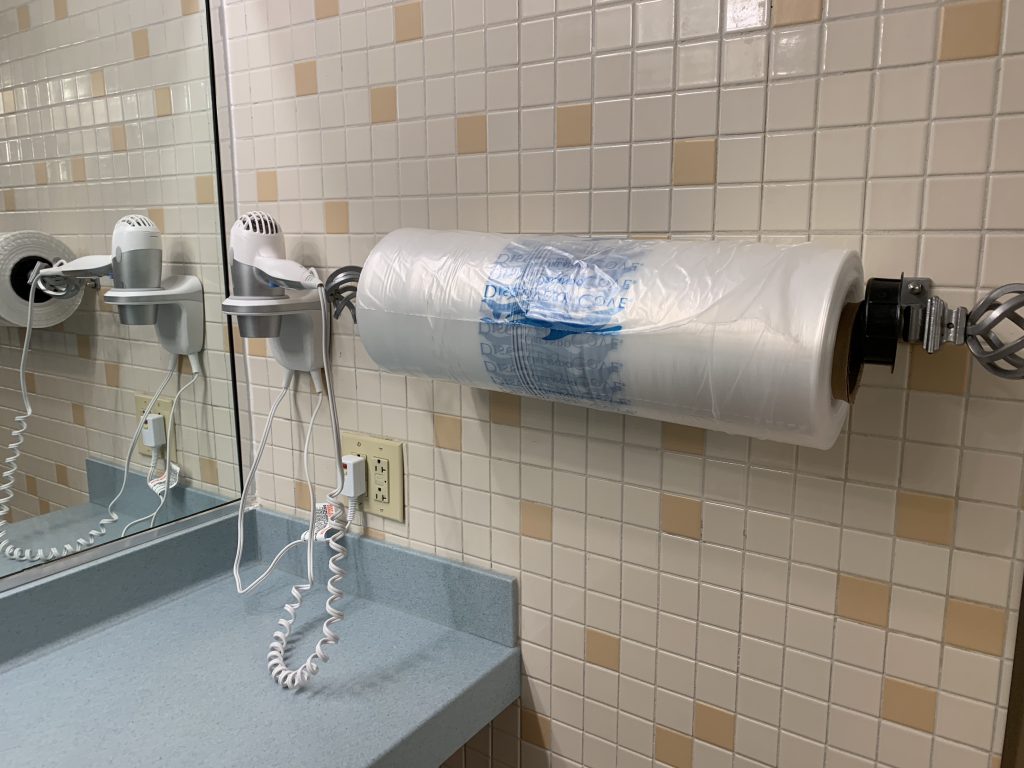 large roll of plastic bags hanging on wall in bathroom