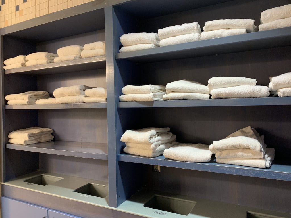 blue shelves with white towels stacked in Discovery Cove