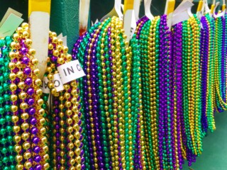 purple green and gold Mardi Gras beads hanging on hooks