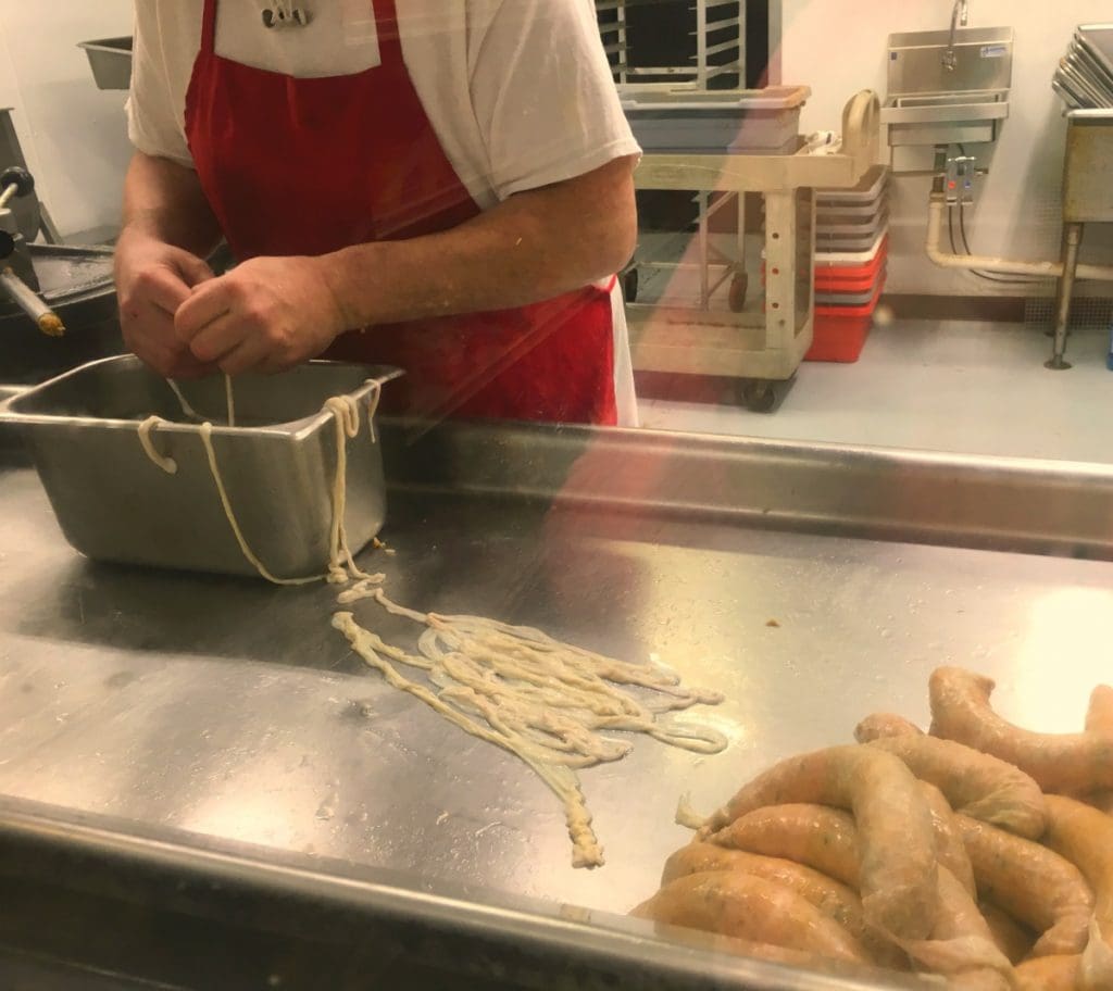 man making boudin sausage in factory