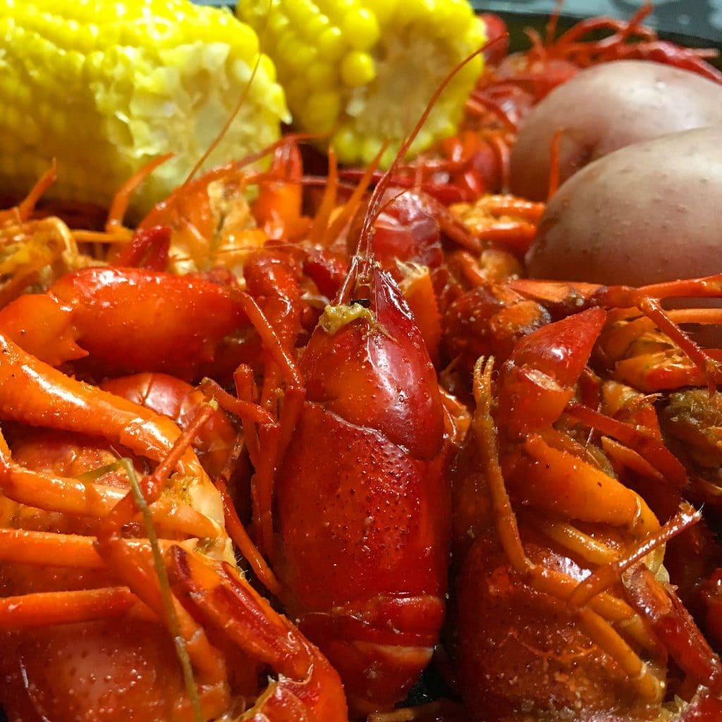 crawfish, potatoes and yellow corn in a cast iron pot