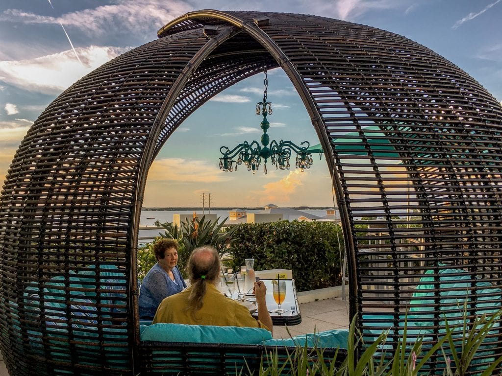 woman and man sitting in chairs under wicker canopy with rooftop view Punta Gorda fl