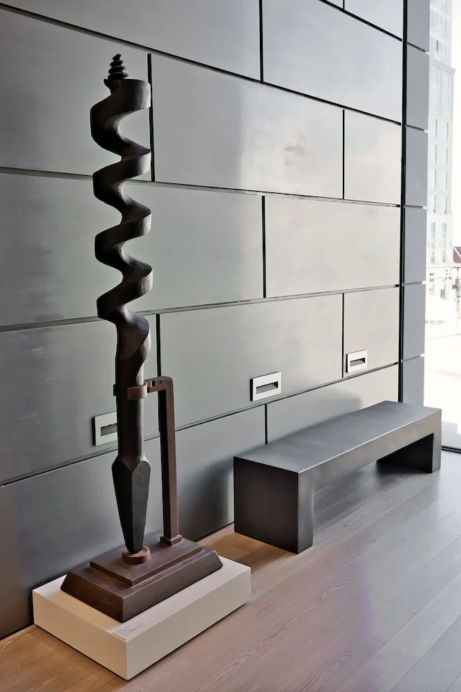modern art metal sculpture against grey wall 