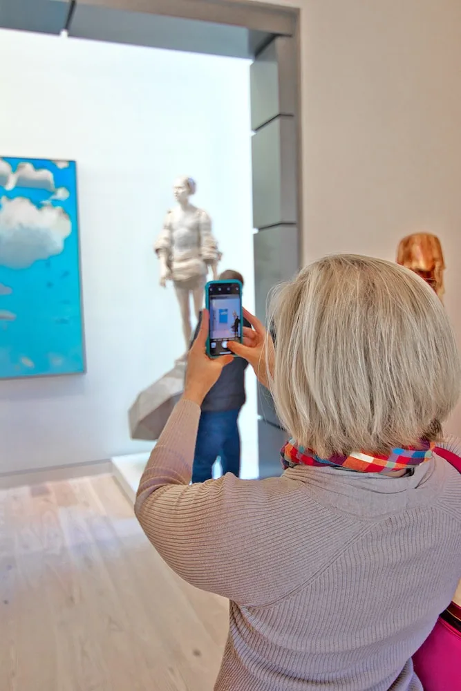 woman taking a photo of art with cell phone