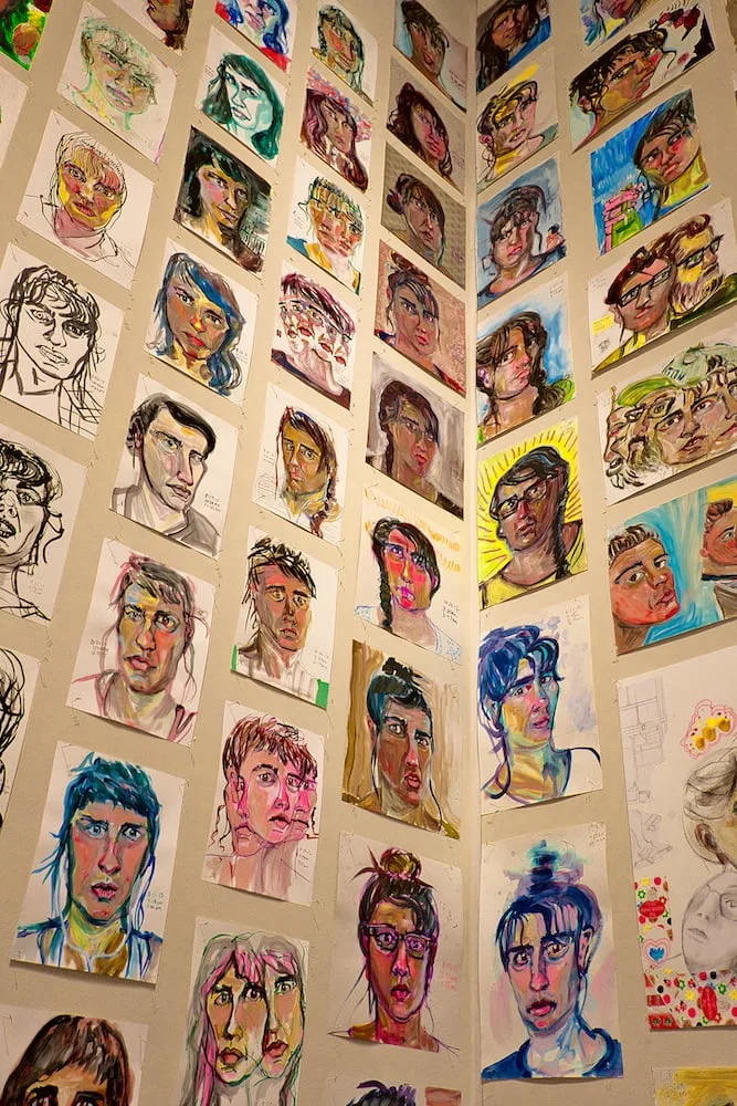 self portrait drawings hung on a wall