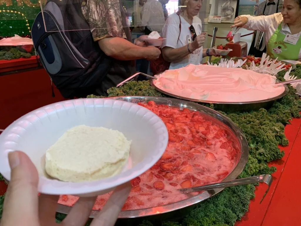 woman holding a biscuit to make a strawberry shortcake at plant city festival