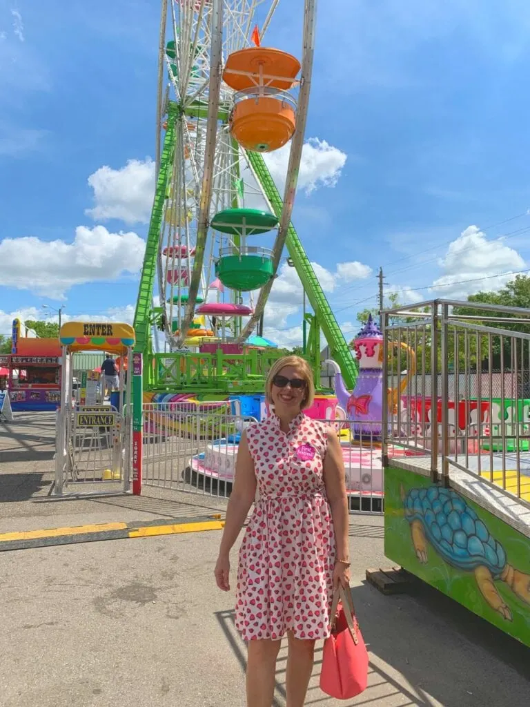 woman standing in front of Ferris wheel at Florida strawberry festival