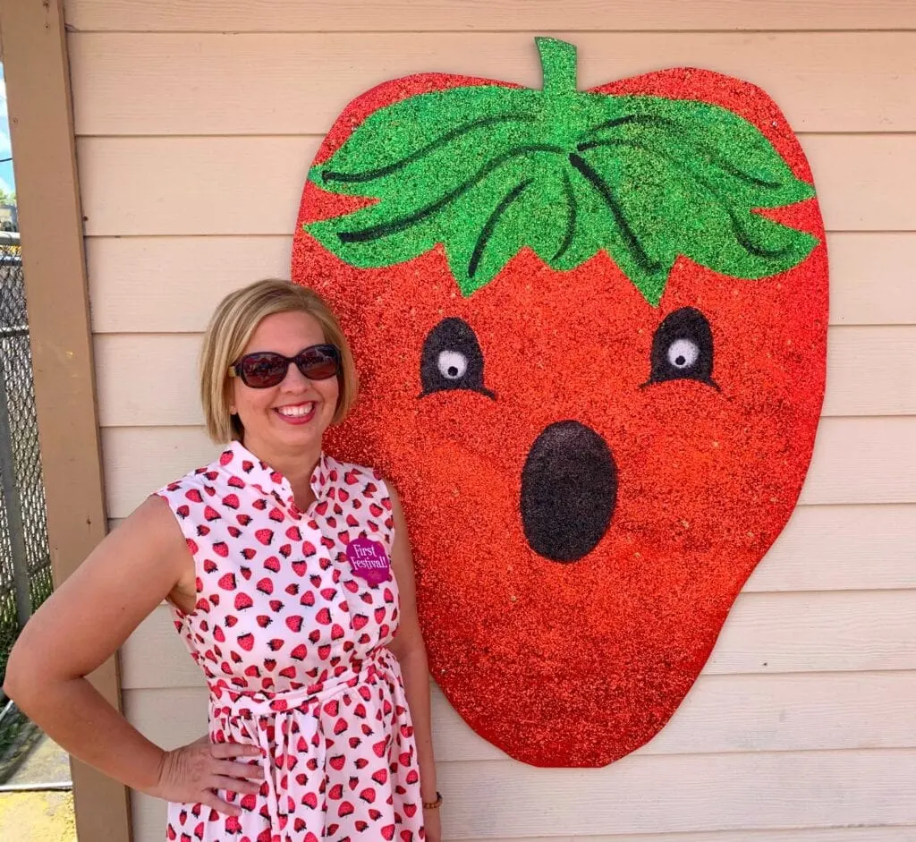 woman standing next to strawberry art on wall