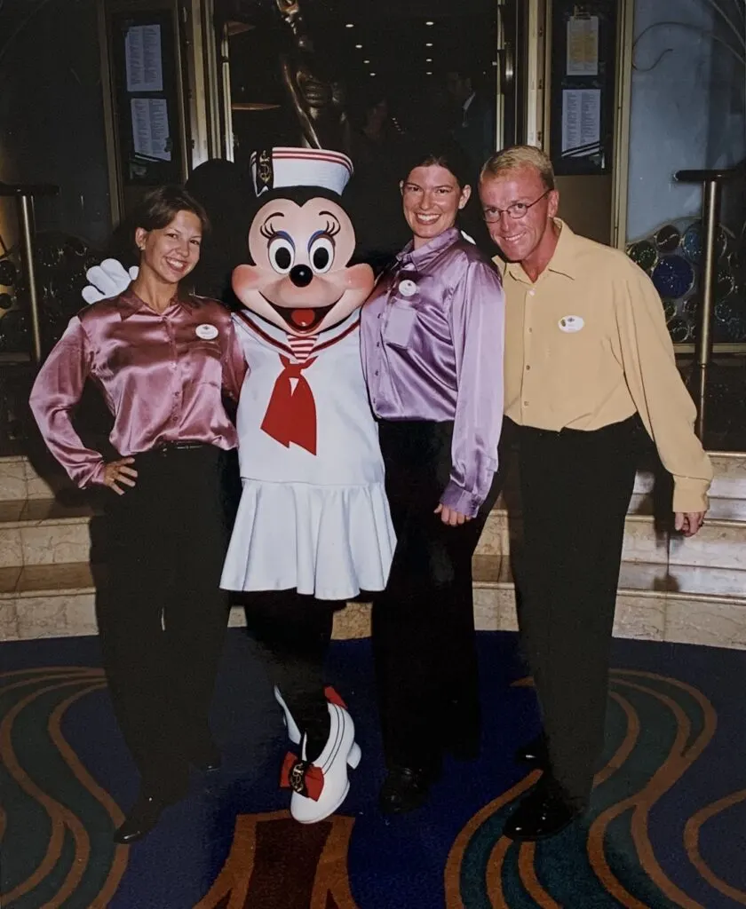 two girls and a guy posing with Minnie Mouse character