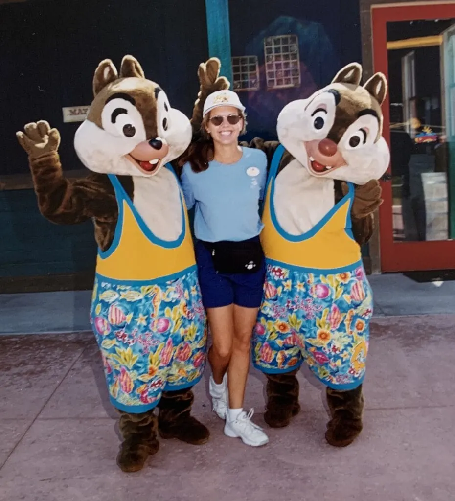 cruise ship worker posing with Chip and Dale wearing swimsuits