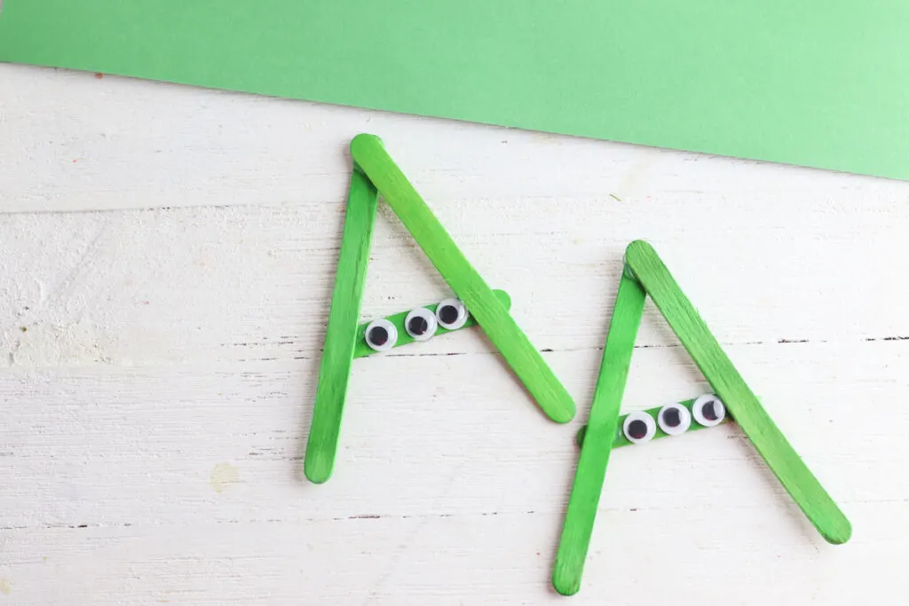 green popsicle sticks in shape of alien