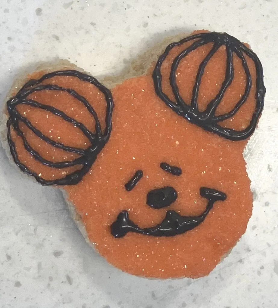 making Mickey Mouse face with frosting on snack treat