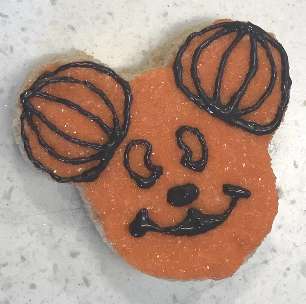 making Mickey Mouse face with frosting on Rice Krispy treat