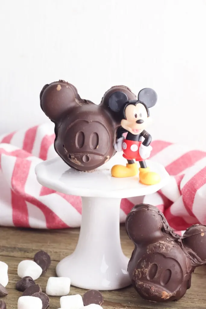 Mickey Mouse shaped chocolate molds on white pedestal with marshmallows around