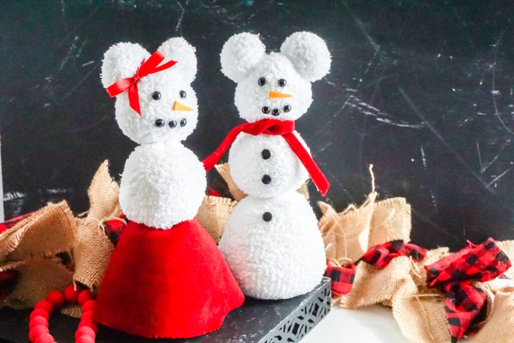 two stuffed sock snow people in shape of Mickey and Minnie Mouse