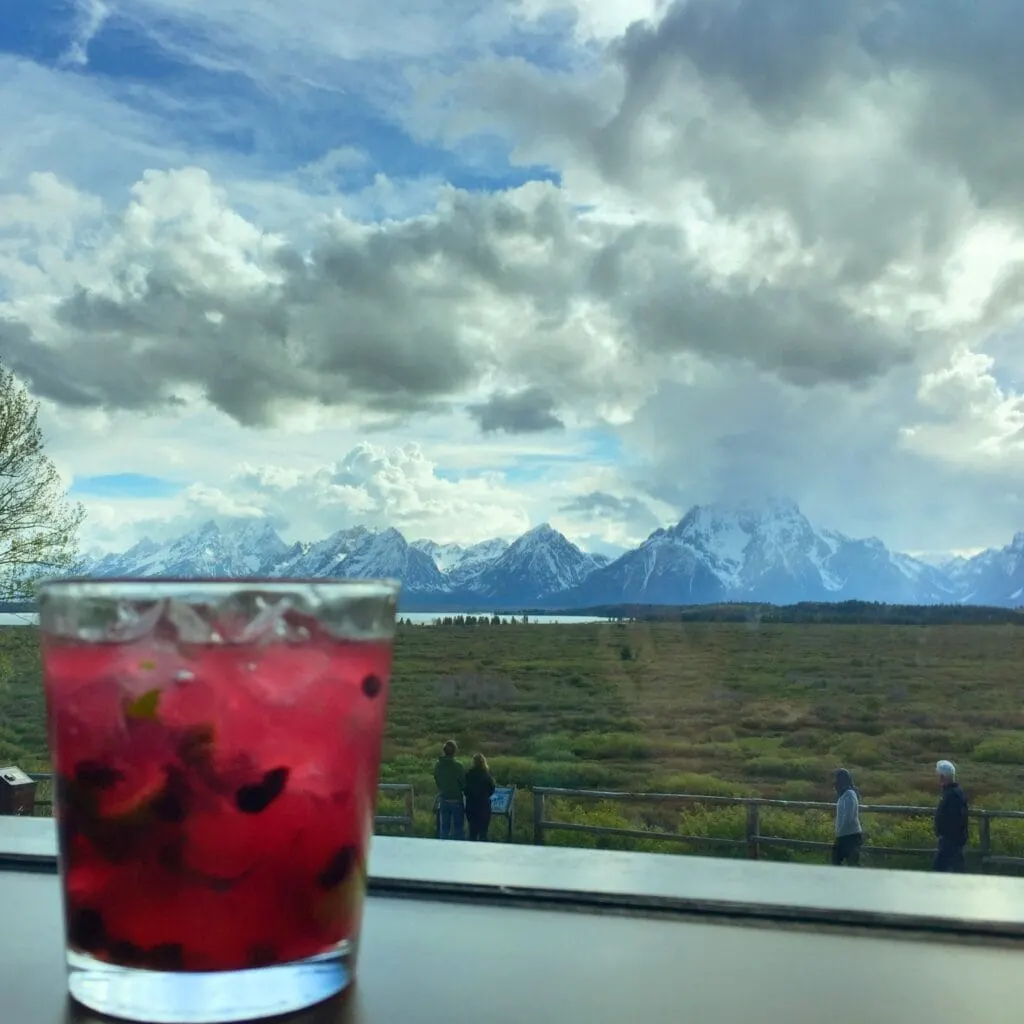 huckleberry cocktail on table with Mountain View in distance