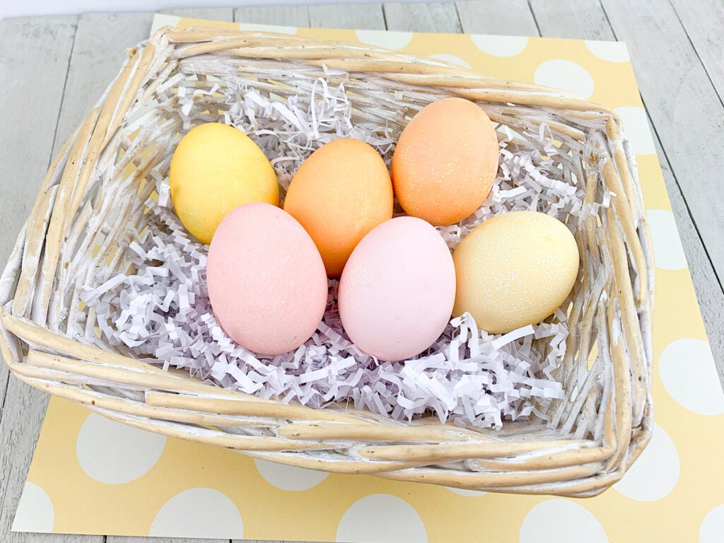 Easter Eggs dyed With Kool Aid in basket on yellow background