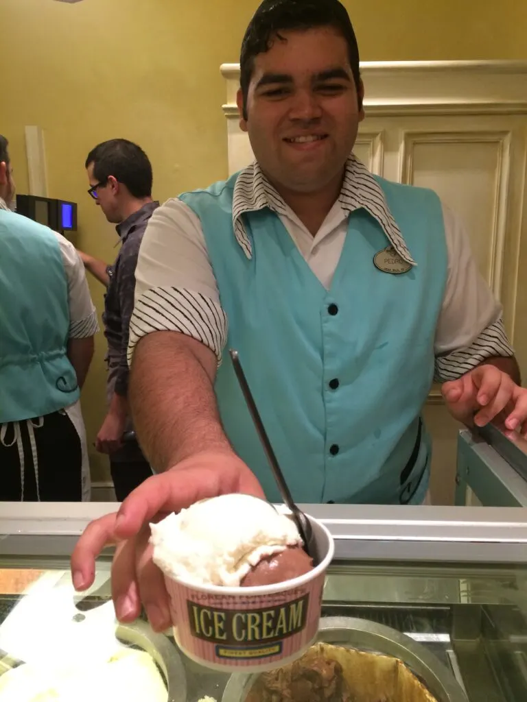 man serving a scoop of ice cream to a guest