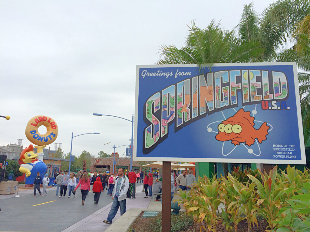 sign for Springfield USA land with Lard Lad Donuts statue in background