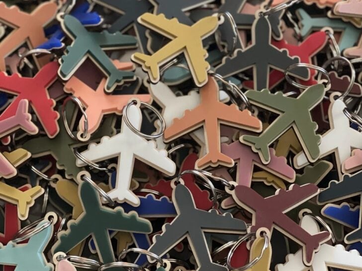 A pile of colorful airplane-shaped keychains overlapping each other, shown in various colors including green, white, red, and yellow&mdash;perfect as fun and practical flight attendant gifts.