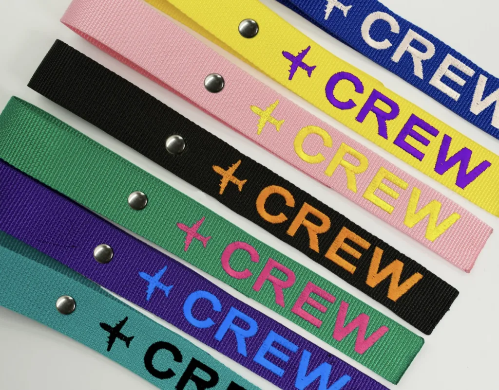 luggage tags in variety of colors with word CREW embroidered